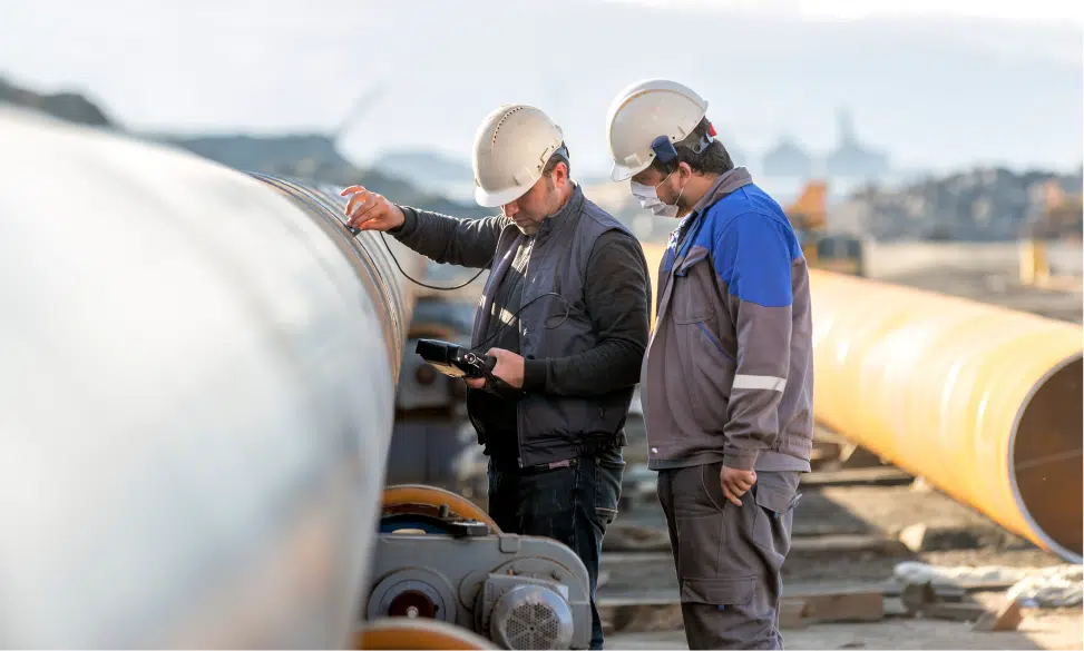 technicians testing welds on pipe with ultrasonic test methods