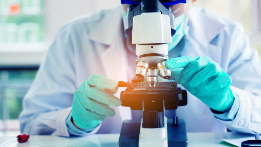 Biologist studies subject under a microscope