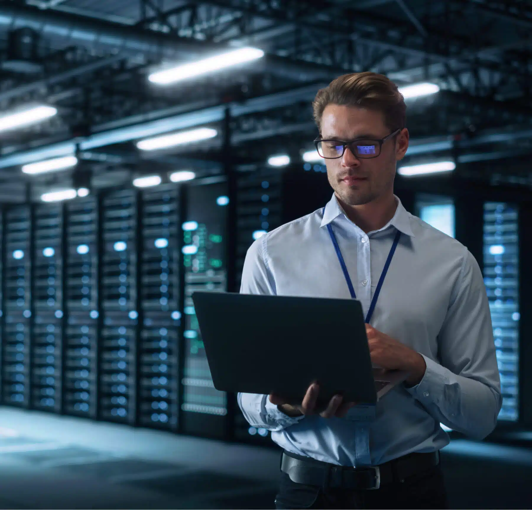 Man who works in IT working on laptop in a server room