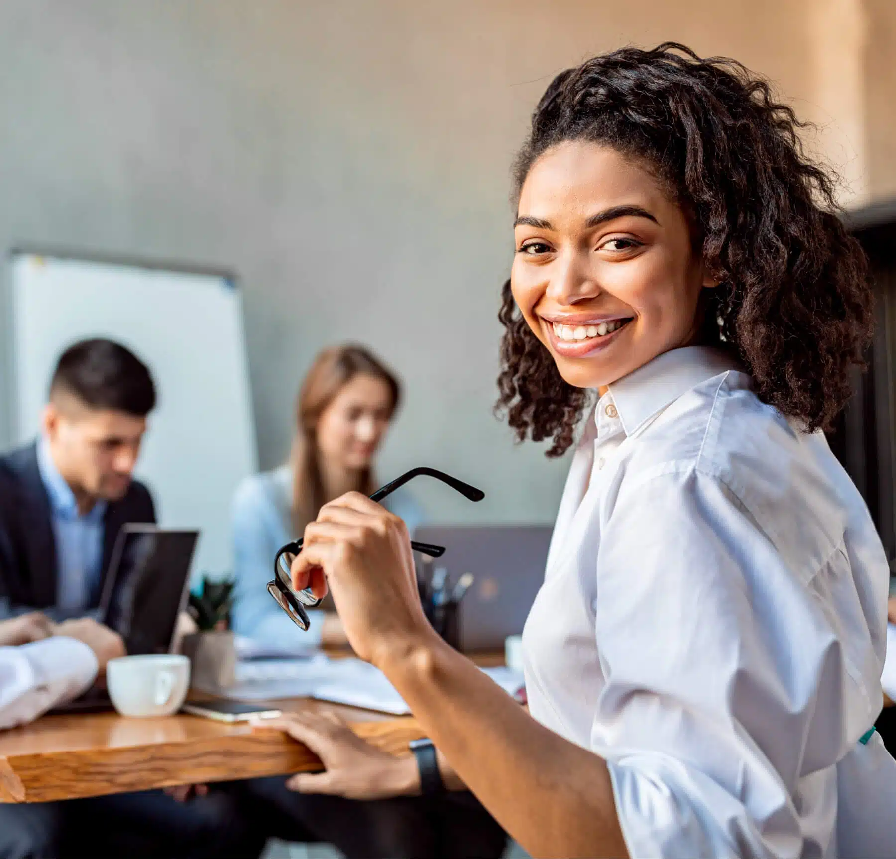 smiling businesswoman with team at a meeting