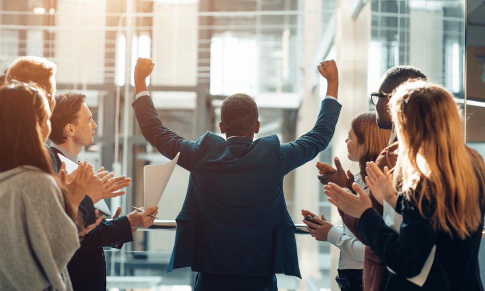 Man walking out of interview with team clapping while he heads out